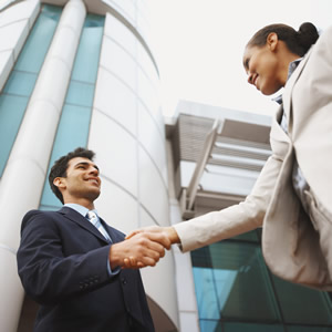 Two businesspeople shake hands outside the office.